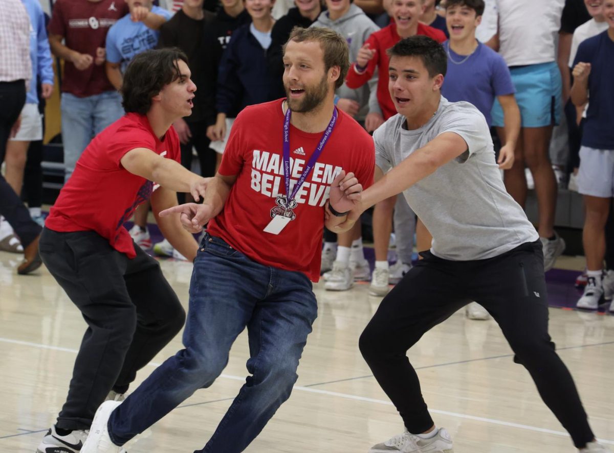 Mr. Schlecht, whisked away by two students during Homecoming 2024-25