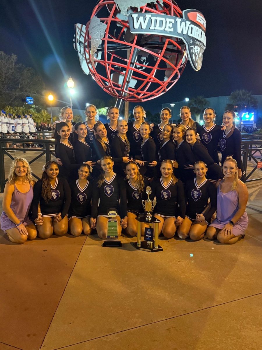 The Varsity cheer team showing off their trophies at Nationals