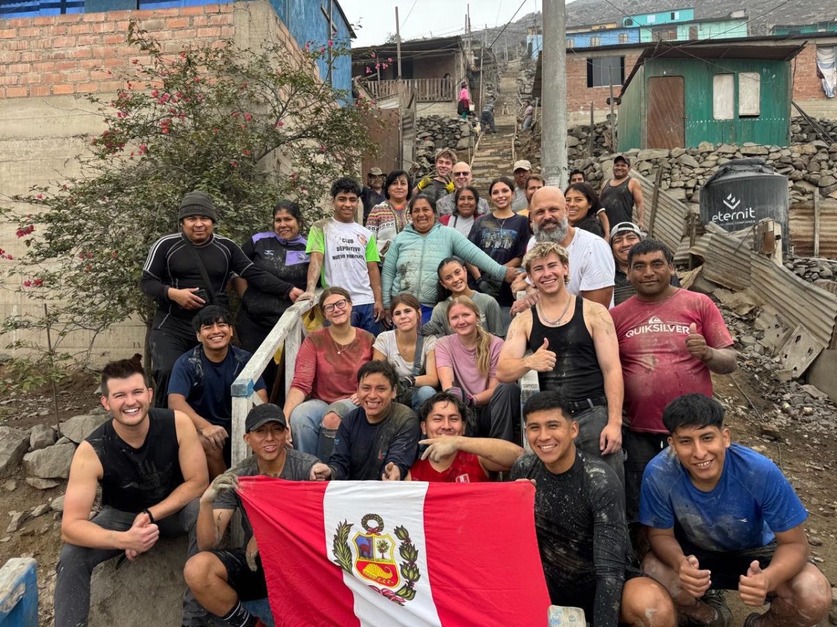 The Lost Children of Peru team huddles together with their flag