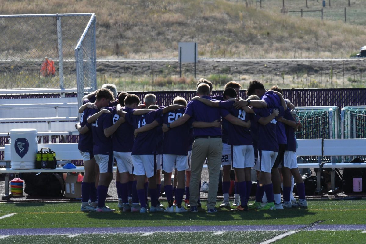 The Lutheran Boys Soccer team huddle together before a game.